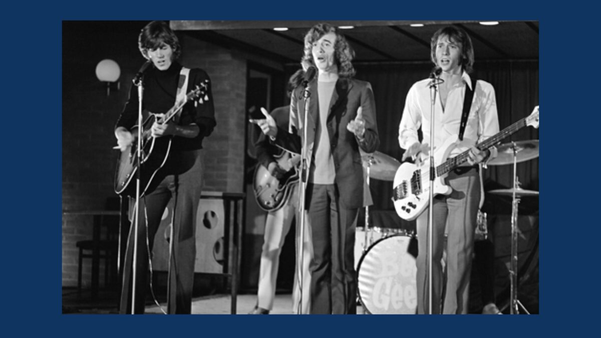 Black-and-white photo of the Bee Gees performing on stage in the 1970s
