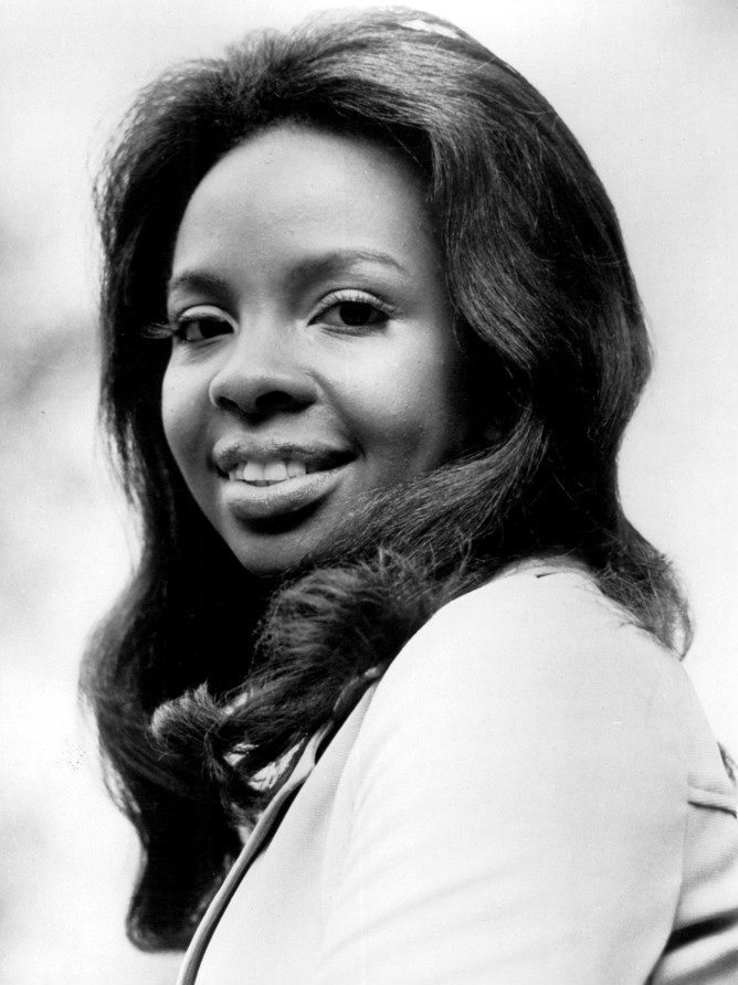 Black and white 1974 CBS Television publicity photo of Gladys Knight, the voice behind the Gladys Knight songs of the 70s, smiling in a dark top