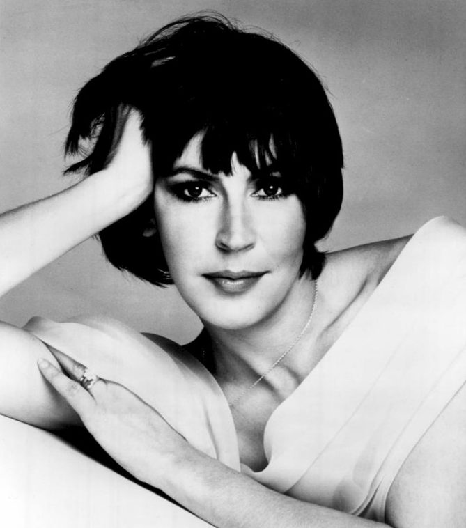 Black and white 1975 publicity portrait of Helen Reddy, the singer behind the Helen Reddy songs of the 70s, resting her head on one hand