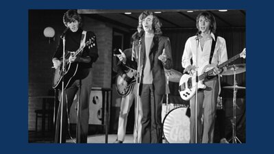 Black-and-white photo of the Bee Gees performing on stage in the 1970s