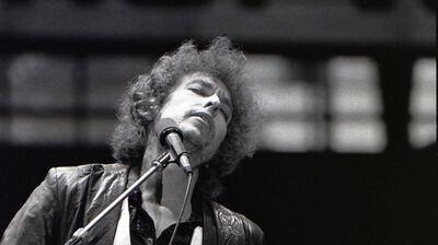 Bob Dylan performs in Rotterdam, June 23 1978, eyes closed at the microphone with a Fender Stratocaster, a folk rock in the 70s songwriter whose own singles never made this site's own chart archive
