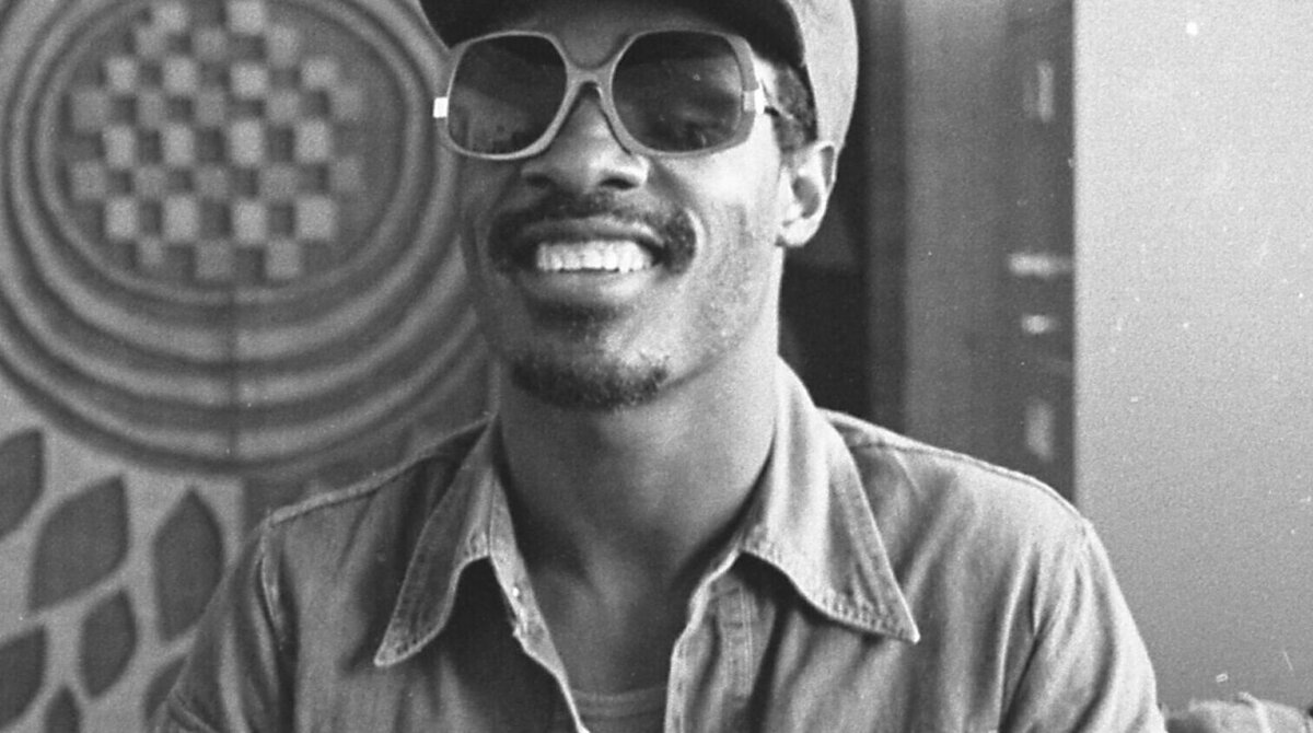 Stevie Wonder in a recording studio in 1975, wearing headphones and sunglasses