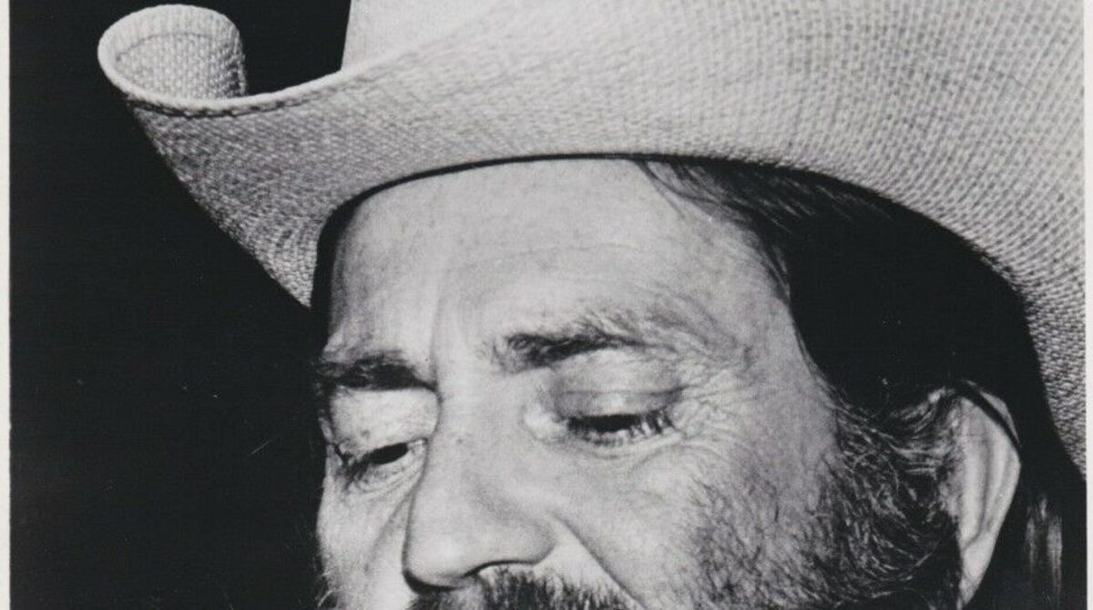 Willie Nelson in a black and white Atlantic Records publicity photo from the early 1970s, wearing a straw cowboy hat and singing into a microphone